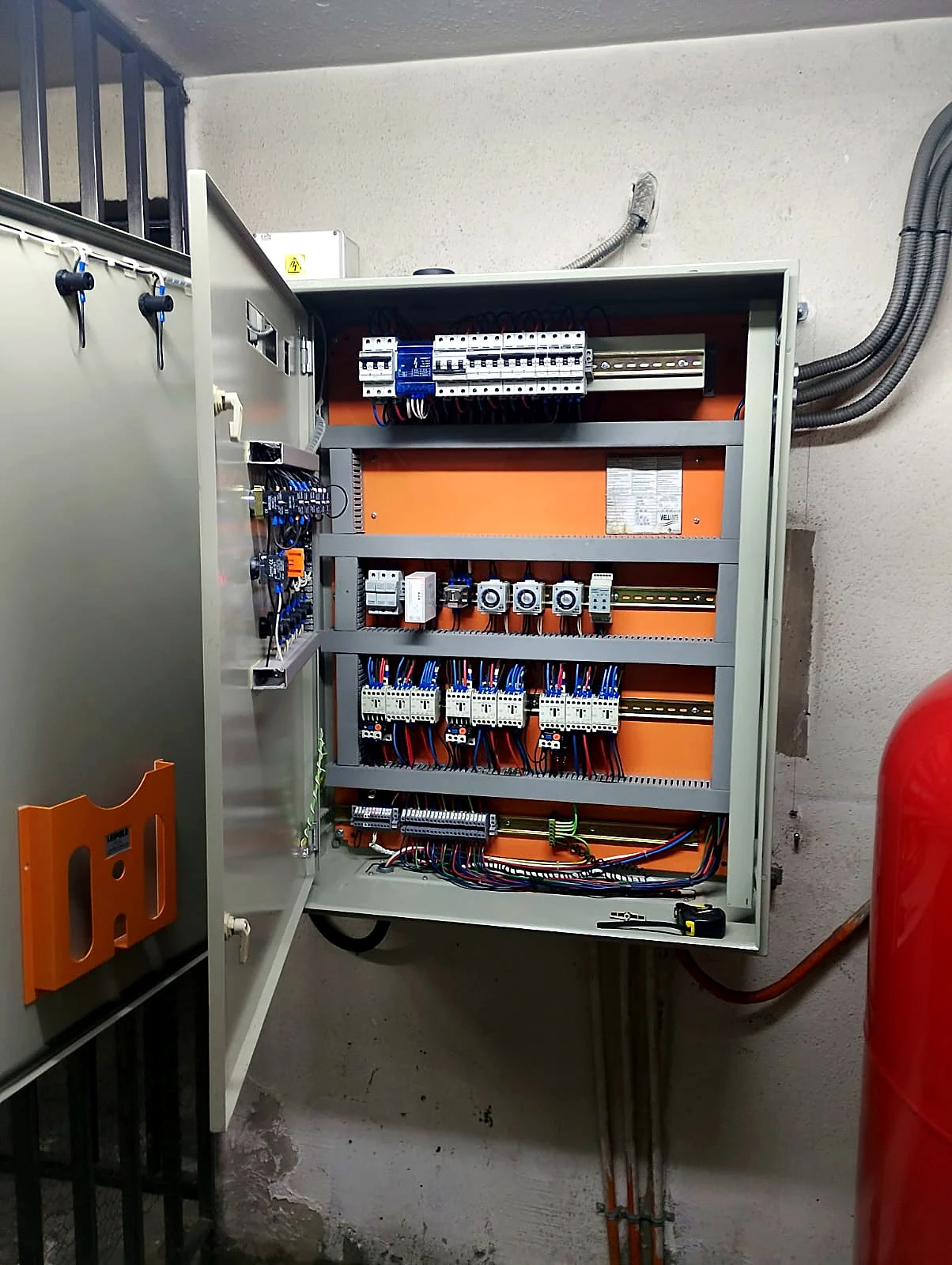 Tablero de fuerza y control abierto, con contactores, relés térmicos y temporizadores ordenados